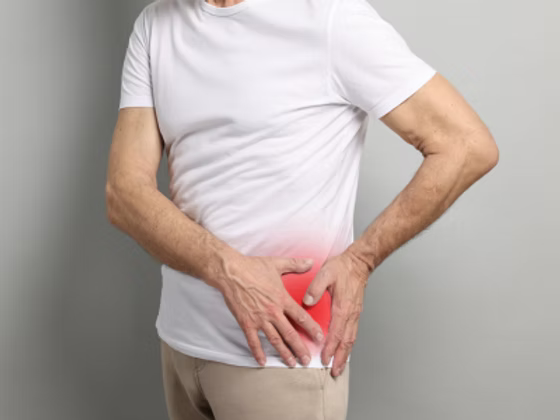 Active adult holding lateral hip area in discomfort before SoftWave shockwave therapy